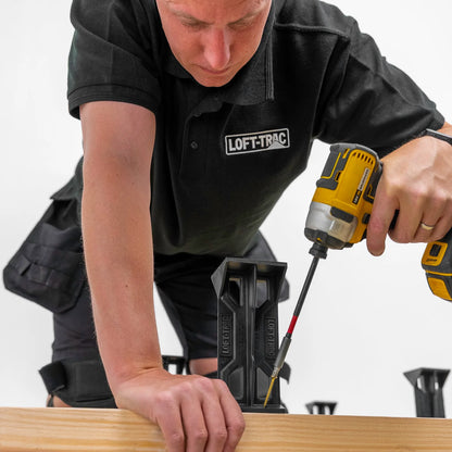Person using a drill with LOFT-TRAC branding on a white background